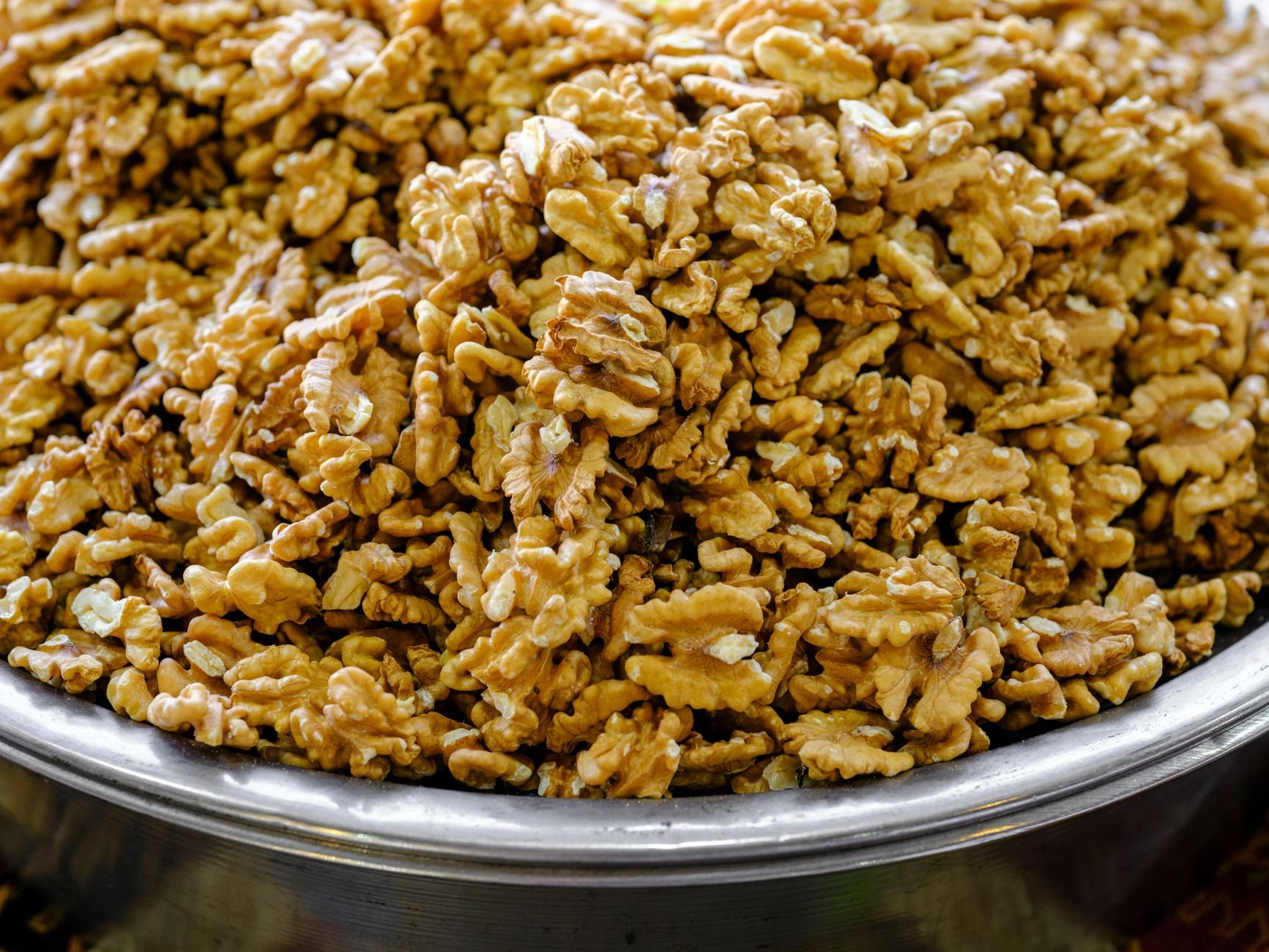 Close-up of walnut kernels in a metal bowl — premium walnut quality