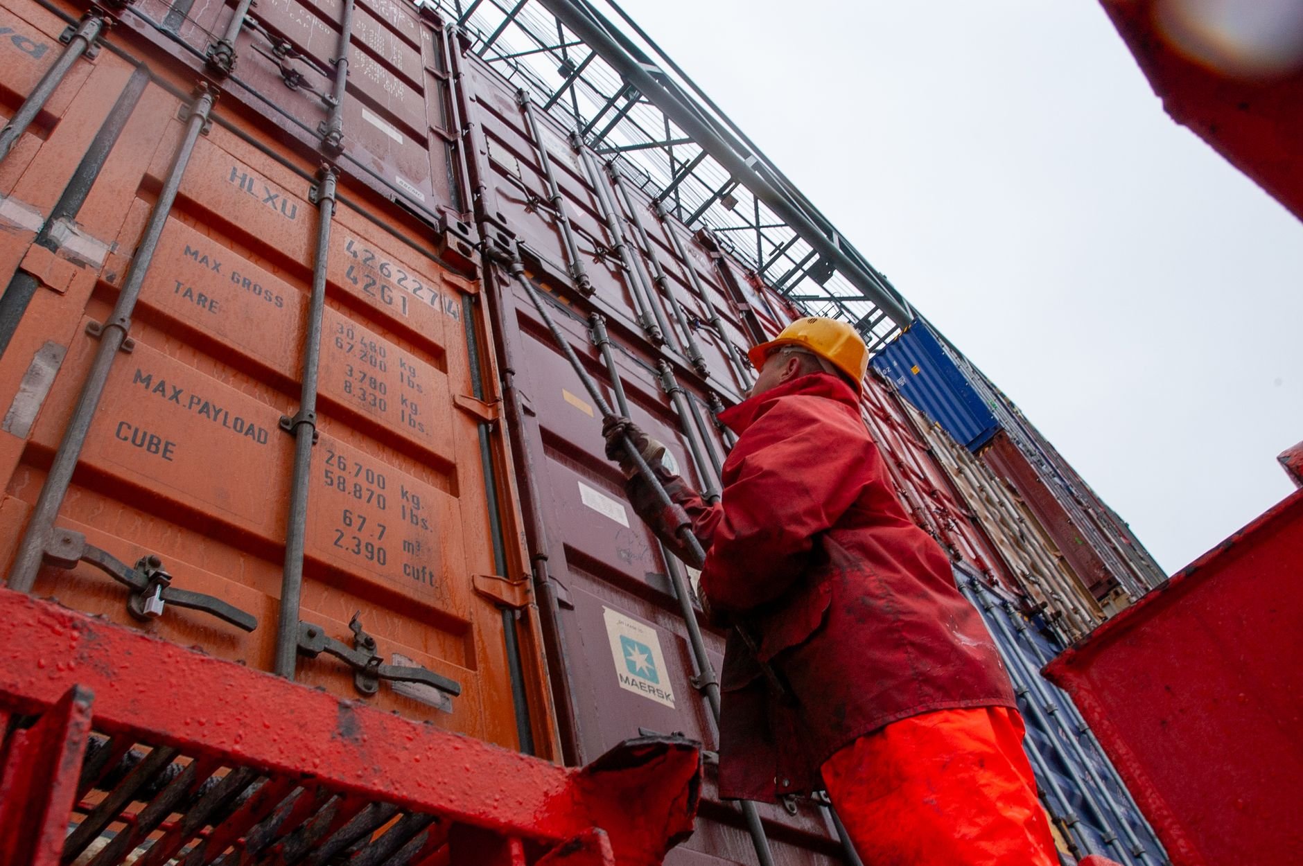 Industrial worker securing cargo at a shipping port — EU logistics